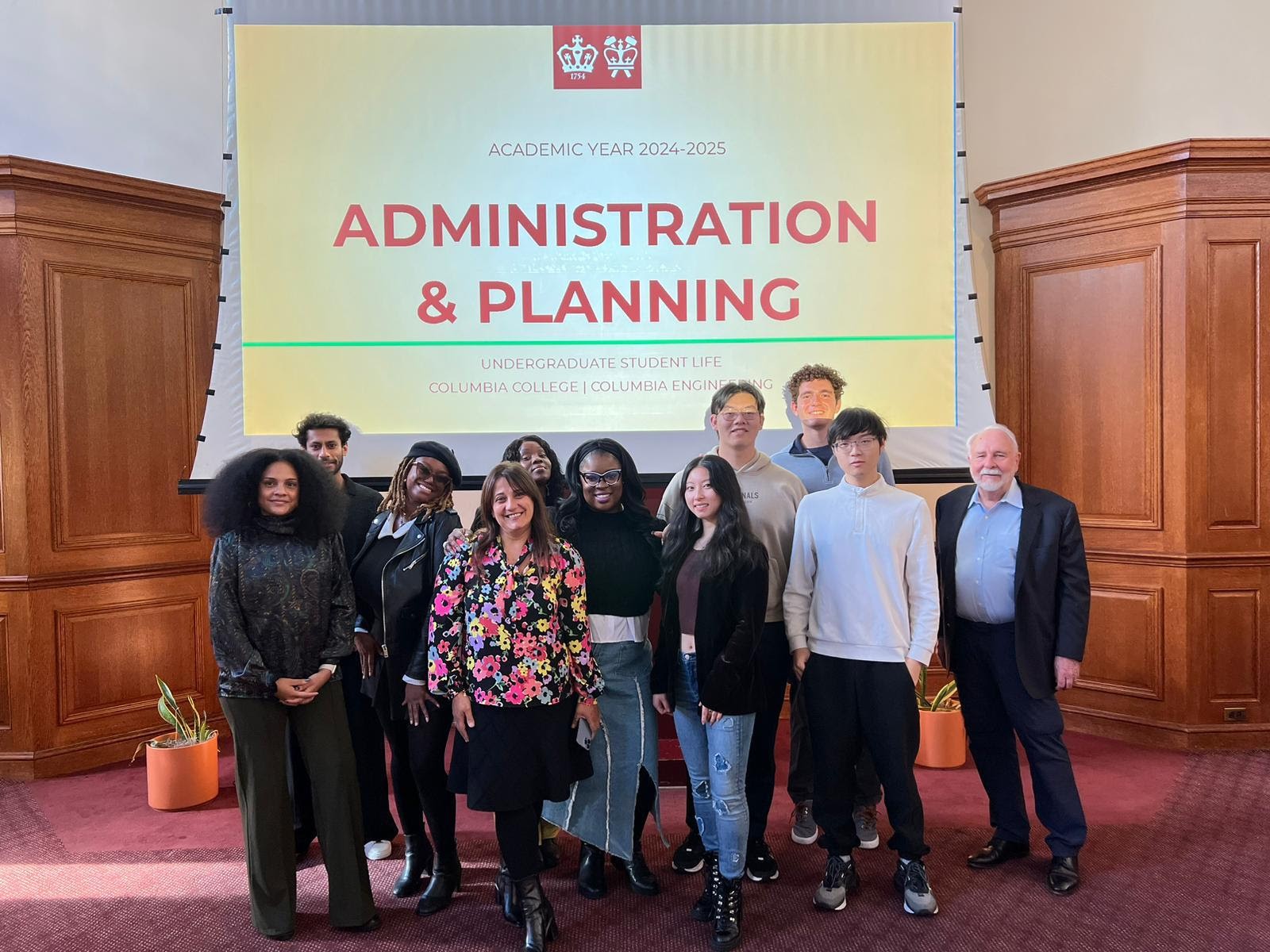 Administration & Planning and ABC members standing in front of projected slide deck